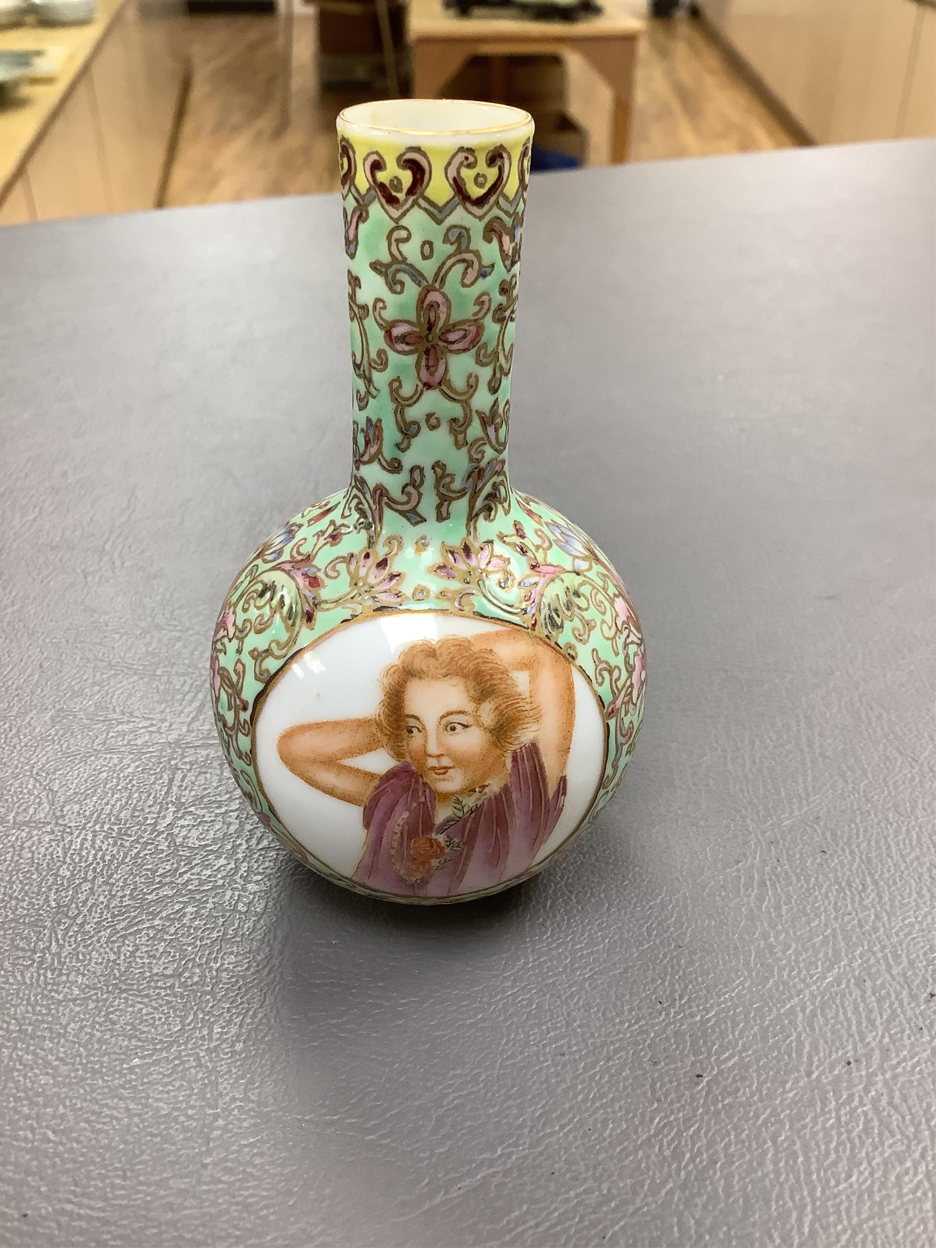 A Chinese enamelled white glass snuff bottle, a blue and white bird feeder and a famille rose vase, the first 9cm